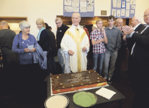 Fr Michael Sweere prepares to cut his morning tea farewell cake.
