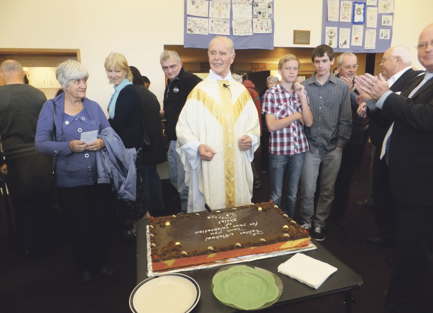 Fr Michael Sweere prepares to cut his morning tea farewell cake.