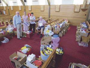 From left, John Woods, Katie Hill, Barbara Maningetti, Paul Franken prepare items for families in need. 