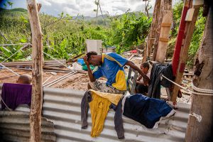 Paulina’s father sits in what remains of their house.  Photo: Crispin Anderlini/Caritas