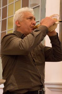 Henare Walmsley heralds the Doors of Mercy opening at Sacred Heart Cathedral by sounding the pūtātara (traditional Māori conch-shell instrument).